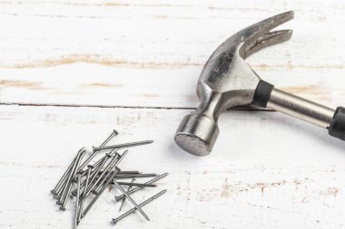 Tahta arka planda çekiç ve çivi