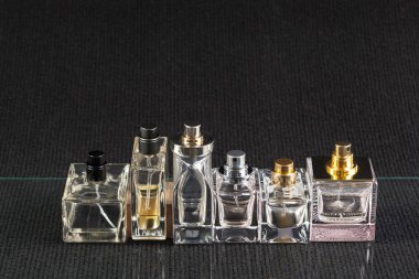 Koyu arka plan üzerinde parfüm şişeleri görünümü Kapat