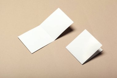 Bej renkli bir arka plan üzerinde boş kağıt parçaları için alay et