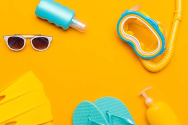 Beachwear ve aksesuarları sarı bir arka plan, seyahat ve tatil kavramı kompozisyon