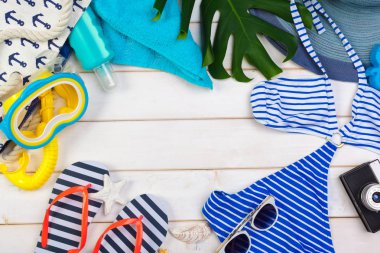 Beachwear ve aksesuar beyaz ahşap zemin üzerinde seyahat kavramı