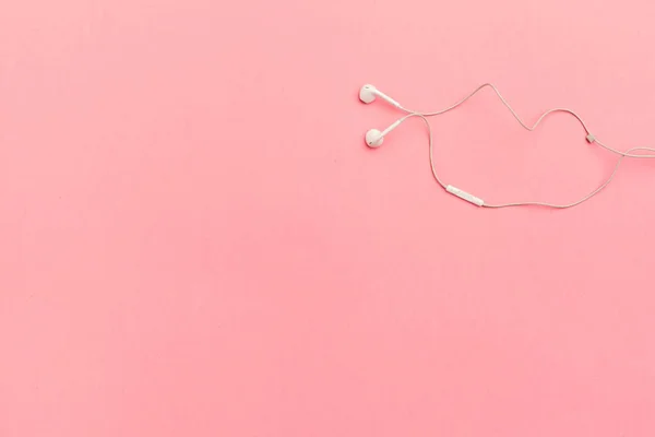White earphones on a colored paper background