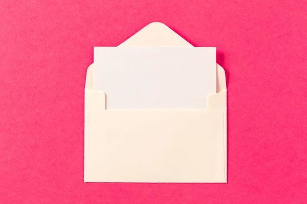 ピンク色の背景の紙封筒 — ストック写真