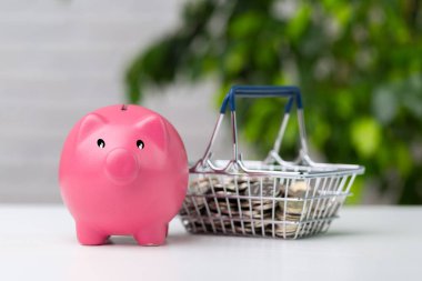 masanın üzerinde alışveriş sepeti ile Piggy banka