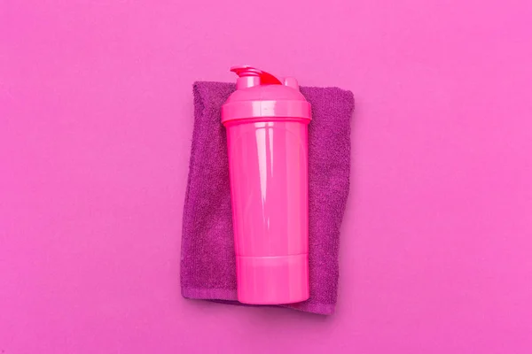 Pink plastic protein shaker cup on pink background