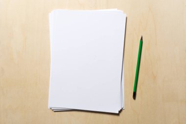 Ahşap masa üzerinde beyaz iş kartı. Boş dikey A4.