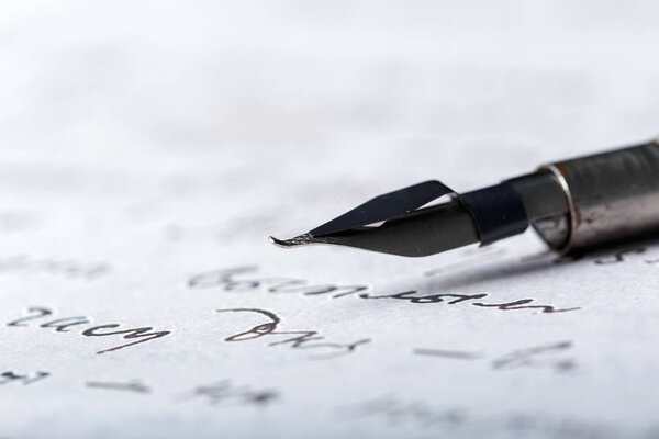 Фонтанная ручка на старинном рукописном письме
