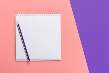 Tasarımınızın üstten görünüm parlak bicolor arka plan üzerinde boş kağıt Not defteri