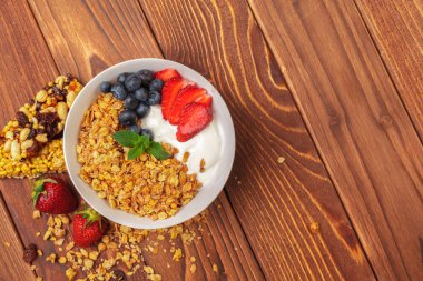 Kase yoğurt ve ahşap zemin üzerine taze çilek ile ev yapımı granola