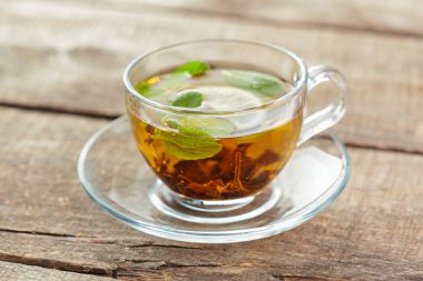 siyah çay nane ile ahşap bir masaya bırakır