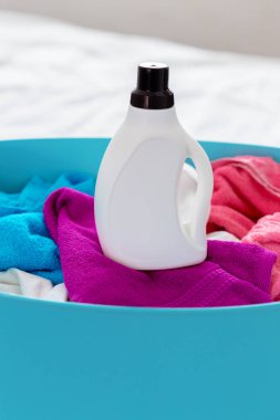 Sepet içinde renkli elbise yığını temizleyici şişe