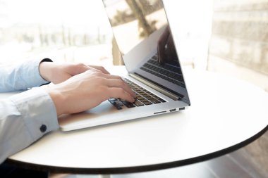 Beyaz adam masada dizüstü bilgisayar kullanarak