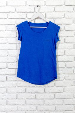 Temel t-shirt tuğla duvar arka plan üzerinde pamuk