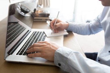 Beyaz adam masada dizüstü bilgisayar kullanarak