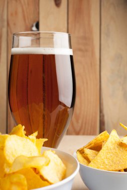 Lager bira cam ve ahşap arka plan üzerinde gevrek patates cipsi