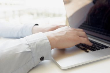 Beyaz adam masada dizüstü bilgisayar kullanarak