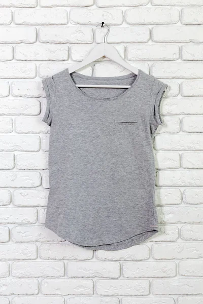 Temel t-shirt tuğla duvar arka plan üzerinde pamuk