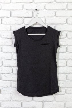 t-shirt ile tuğla badanalı duvara askı