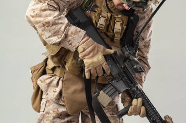 Kamuflajlı asker elinde tüfekle