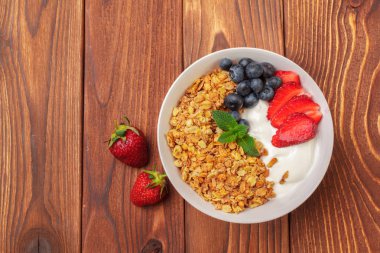 Kase yoğurt ve ahşap zemin üzerine taze çilek ile ev yapımı granola