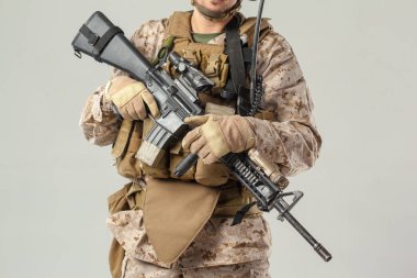 Kamuflajlı asker elinde tüfekle