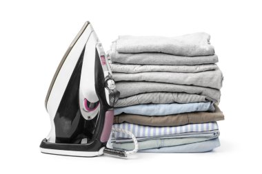 Elektrik demir ve beyaz arka plan üzerinde izole elbise yığını 