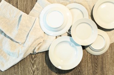 Bir masa örtüsü ahşap arka plan üzerinde beyaz tabaklar 