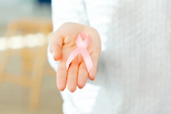female hands holding AIDS awareness ribbon