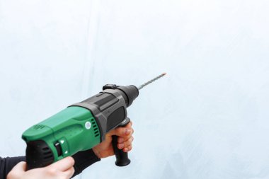 Ellerini kullanarak duvar matkap-matkap çekiç