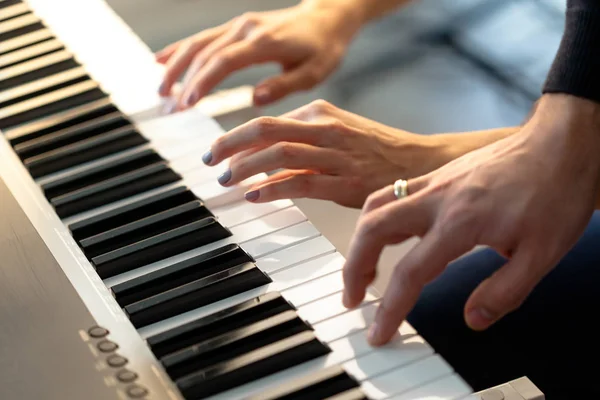 Closeup of hands playing piano. Music and hobby concept