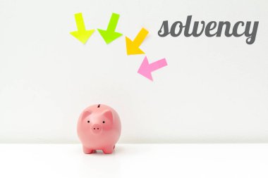 Piggy bank with arrows and word solvency  clipart