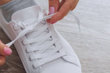 Ahşap arka plan üzerinde ayakkabı bağcığı bağlama kadının görünümü Kapat