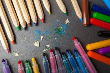 gri taş zemin üzerine renkli kalemler