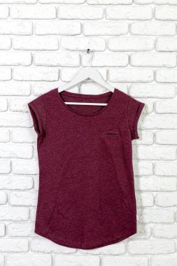 t-shirt ile tuğla badanalı duvara askı