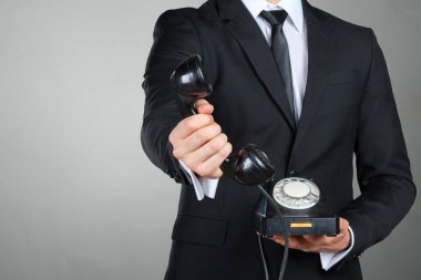 Bir telefon ahizesi tutan işadamı closeup