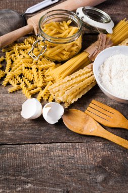 Makarna spagetti eski ahşap arka plan üzerine un, yumurta