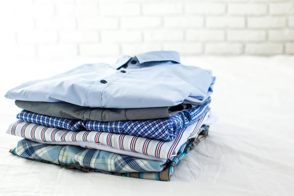 close up of ironed and folded shirts on table at home