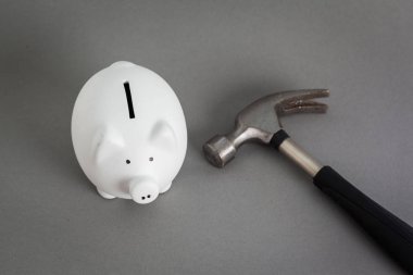 Seramik kumbara pembe ve gri arka plan üzerinde çekiç 