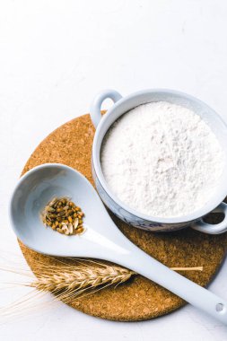 Beyaz arka plan buğday kulaklara kase bütün un