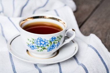 Cup of black tea in a china cup and saucer clipart