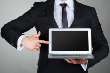 Holding ve dizüstü bilgisayarı gösteren tanınmaz işadamı