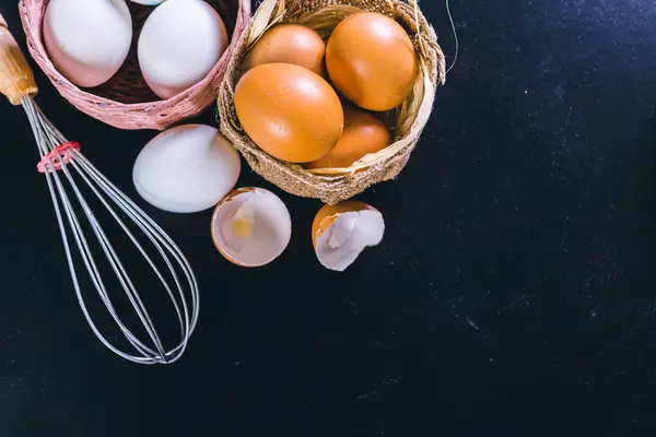 卵と黒の背景に泡立て器 — ストック写真