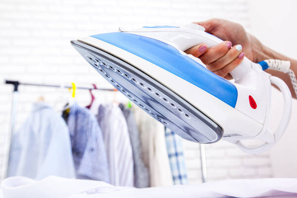 Close up of woman ironing clothes on board