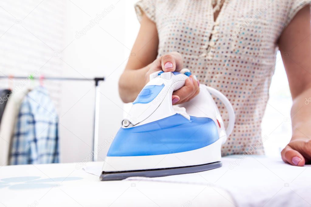 Close up of woman ironing clothes on board
