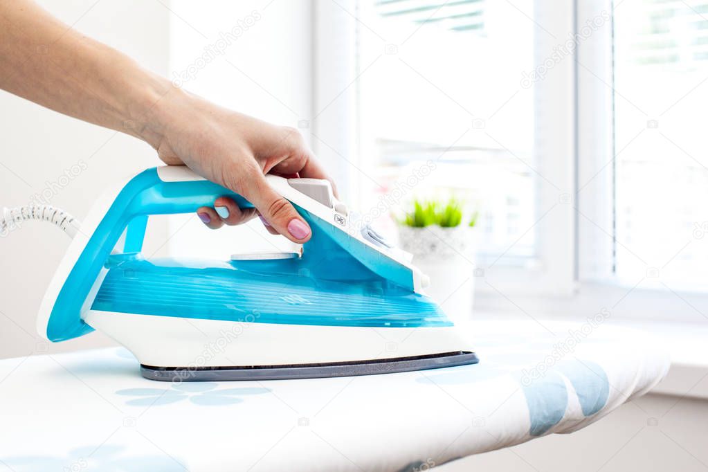 Close up of woman ironing clothes on board