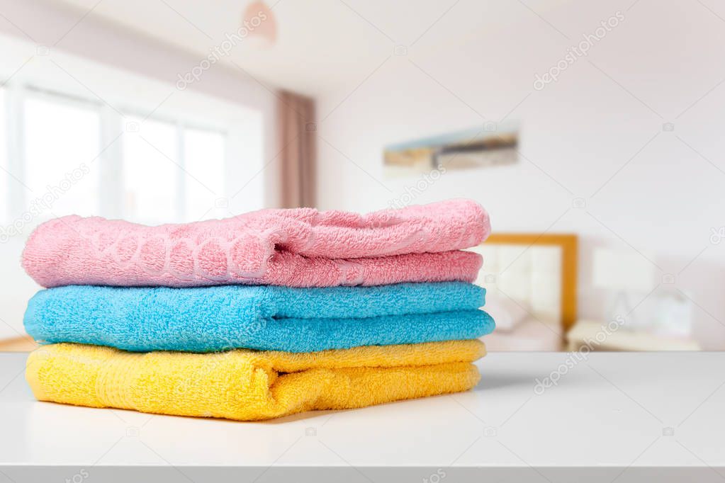 Stack of bath towels on light white background closeup