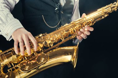 Genç adam saksafon oynamaya yakın çekim 