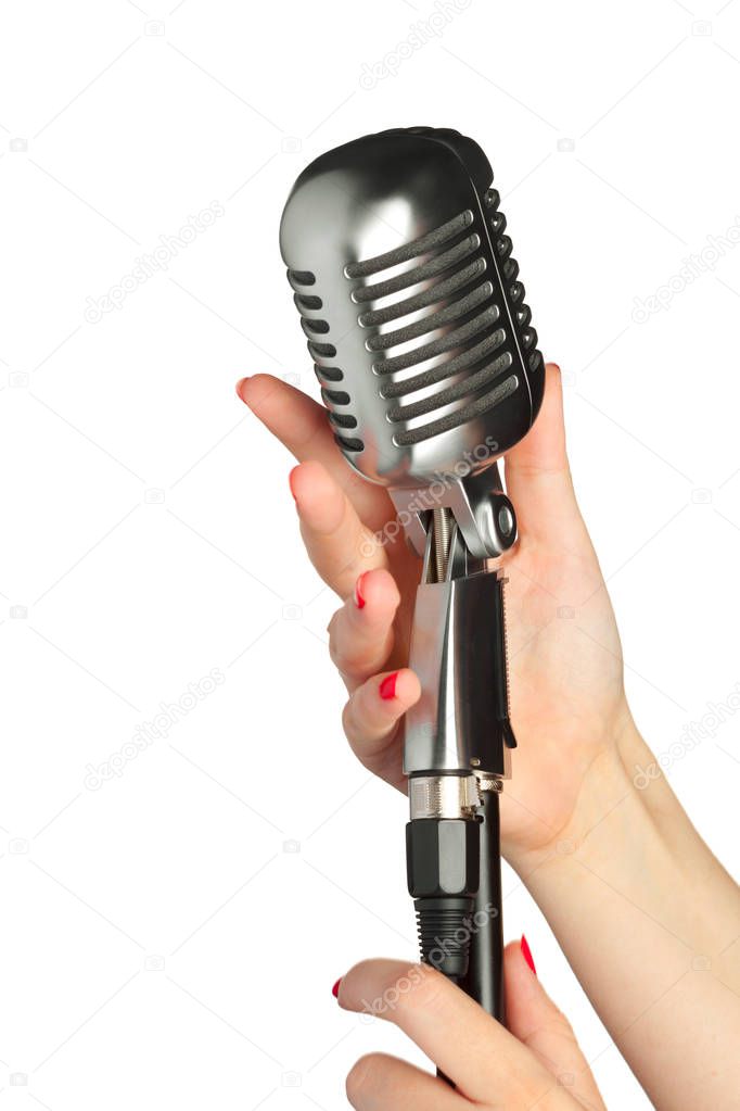 female hands on audio microphone in retro style