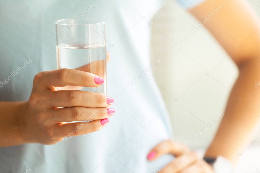 Woman holding a glass of water, close-up