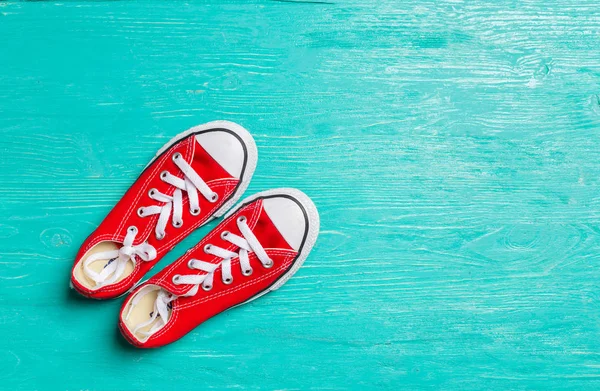 ahşap arka plan üzerinde kırmızı spor ayakkabılar.